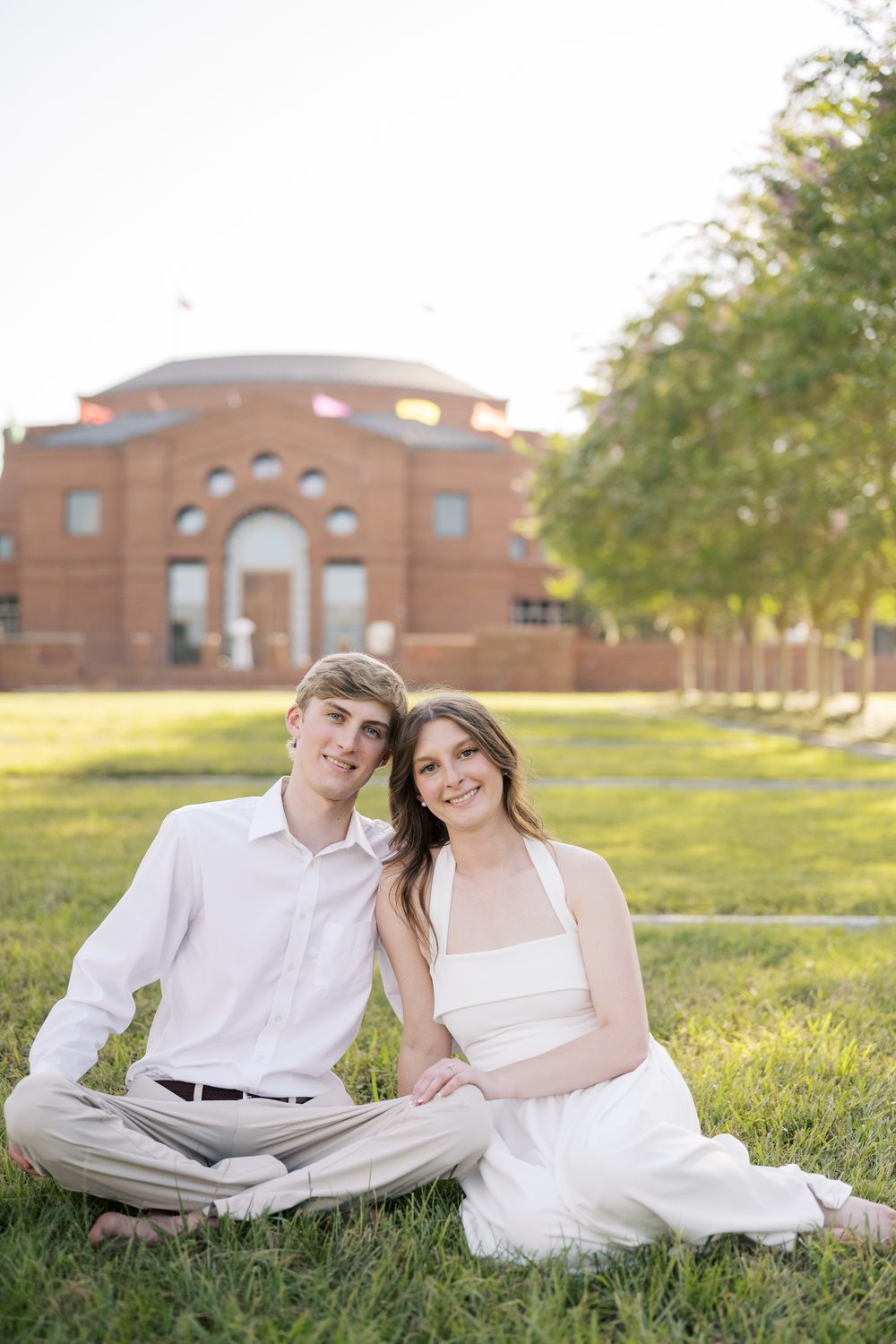 Colton and Ashlyn sitting on the grass together, smiling.