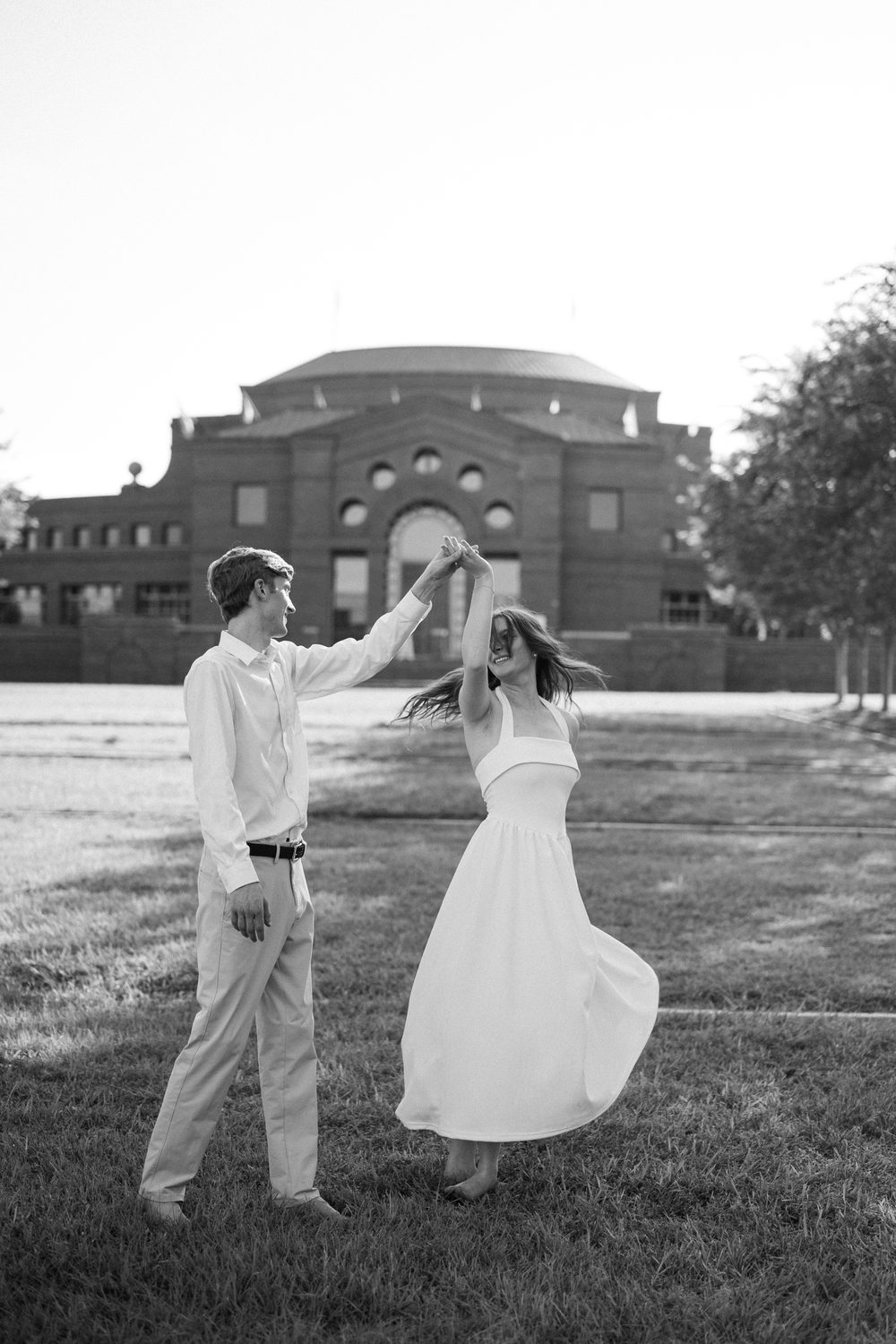 Colton spinning Ashlyn as they dance together, in black and white.