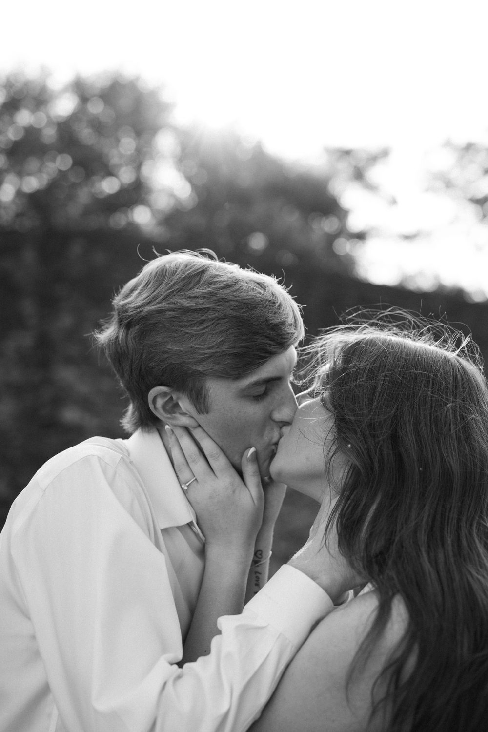 A black and white portrait of Colton and Ashlyn kissing.